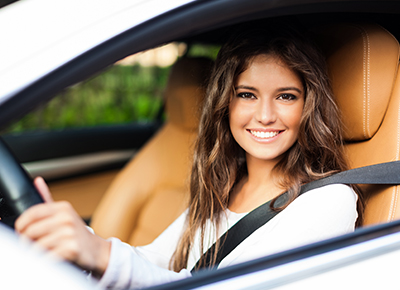 woman behind the steering wheel of a car with auto insurance